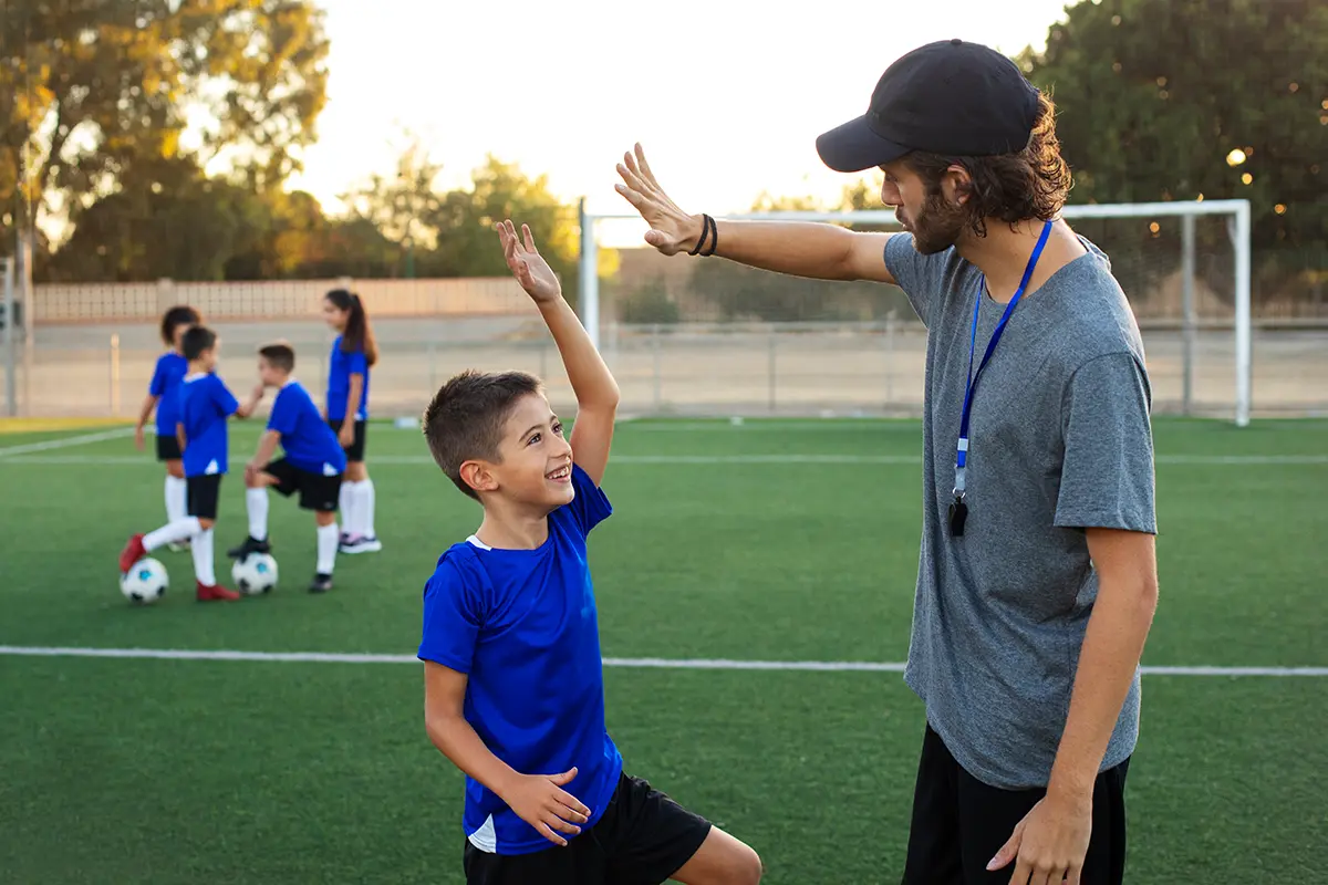 Trainer und Kinder bei einem Sport-Feriencamp